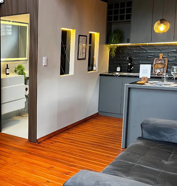 Cocina de The Loft con alacena gris y luces cálidas